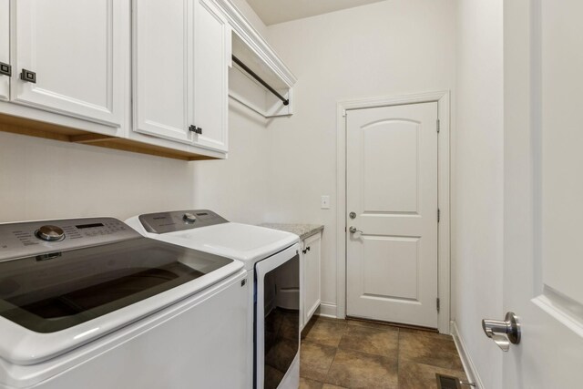 washroom with cabinets and washing machine and dryer