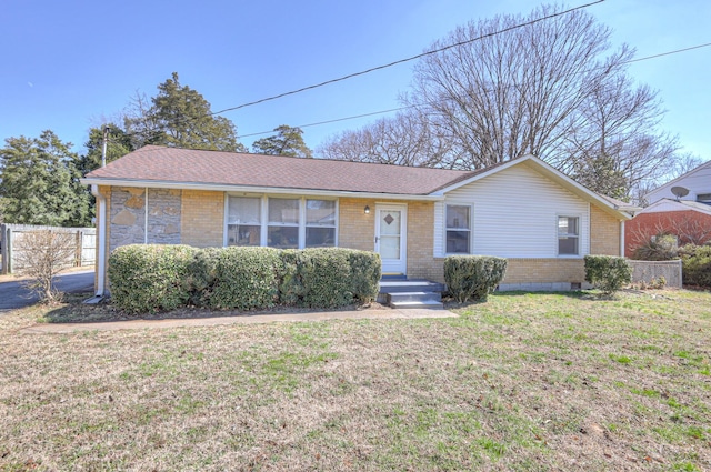 single story home with a front lawn, roof with shingles, fence, and brick siding