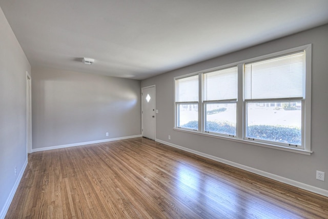 empty room with baseboards and wood finished floors