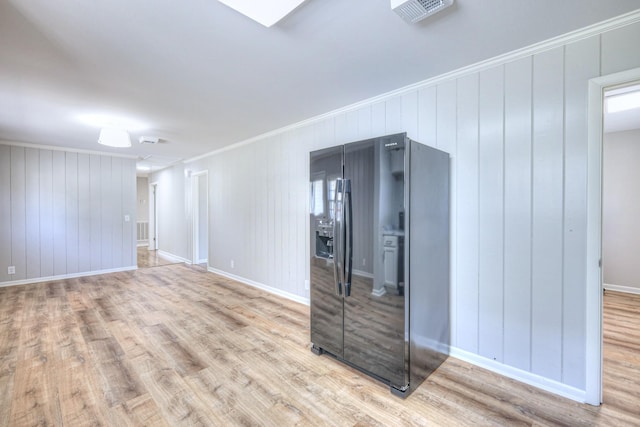 spare room with ornamental molding, wood finished floors, and visible vents