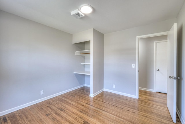 unfurnished bedroom featuring light wood-style floors, a closet, and baseboards