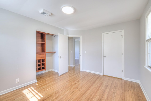 unfurnished bedroom featuring baseboards, a closet, and light wood-style floors