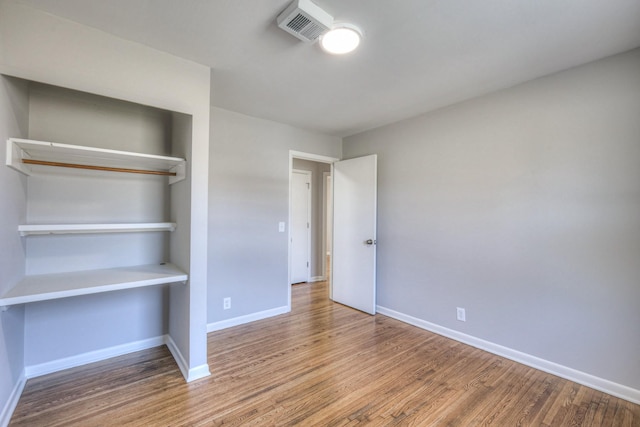 unfurnished bedroom with visible vents, baseboards, and wood finished floors