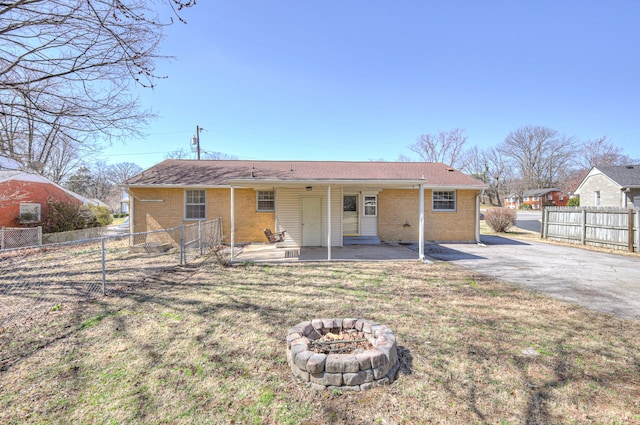 back of house with a patio, brick siding, a lawn, and fence