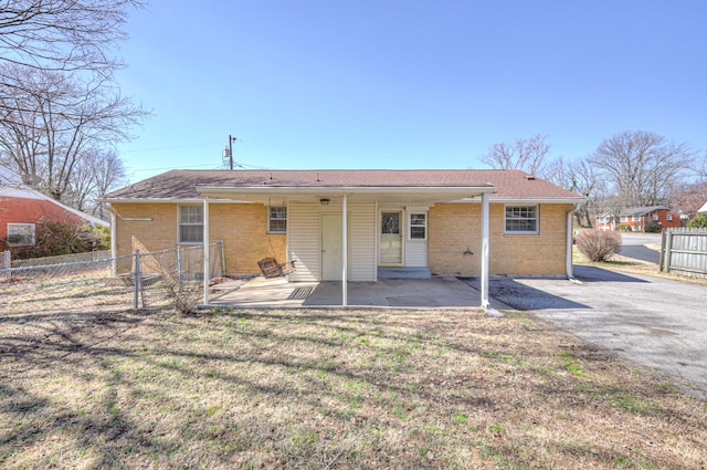 back of property with brick siding, fence, a patio, and a lawn