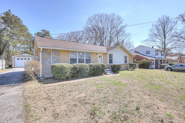 ranch-style house featuring a garage, stone siding, roof with shingles, an outdoor structure, and a front yard