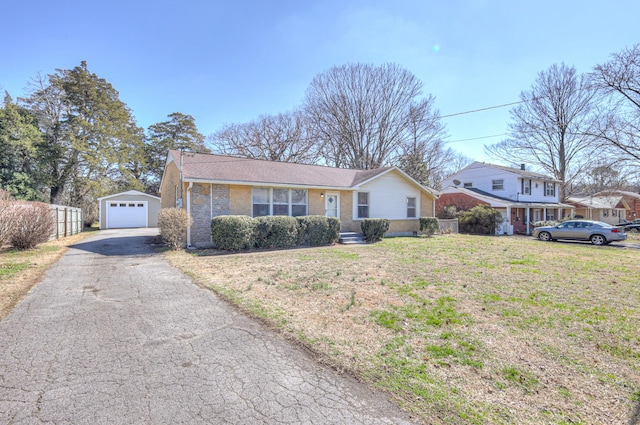 ranch-style home featuring an outdoor structure, fence, a garage, driveway, and a front lawn