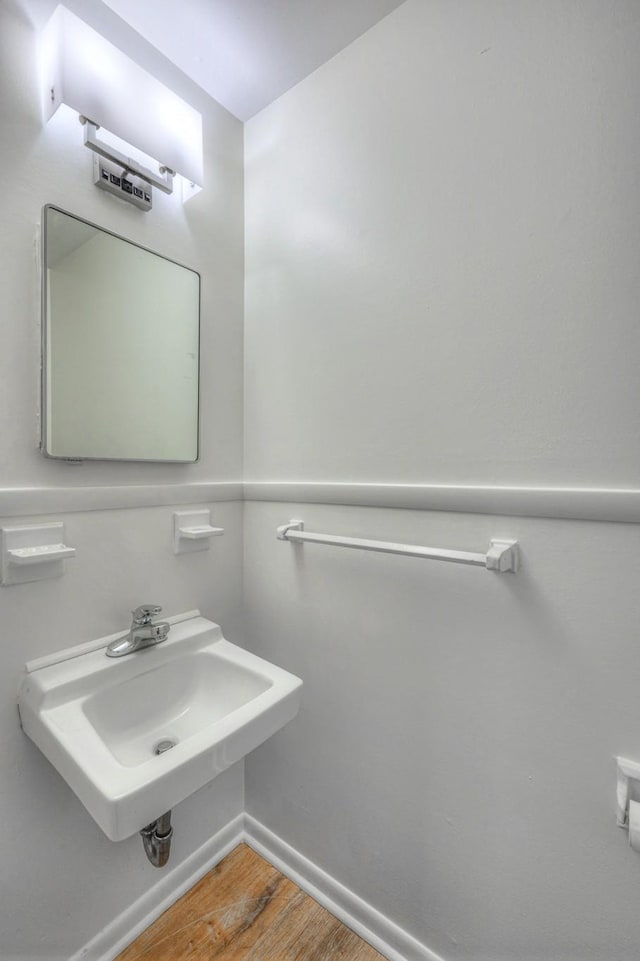 bathroom featuring a sink, baseboards, and wood finished floors