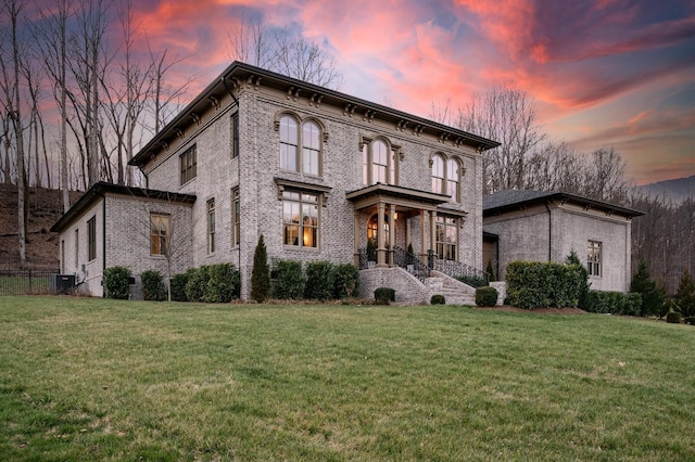 italianate home featuring a lawn and central air condition unit