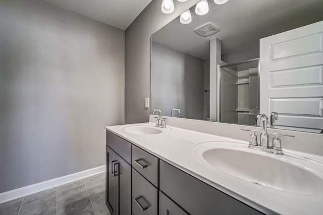 bathroom featuring tile patterned flooring, vanity, and a shower with door