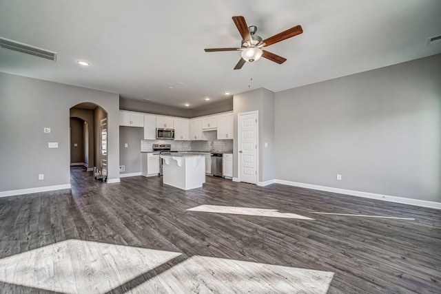 unfurnished living room featuring ceiling fan, dark hardwood / wood-style flooring, and sink