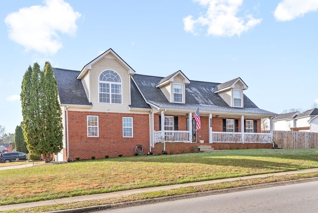 cape cod home featuring a front yard and a porch