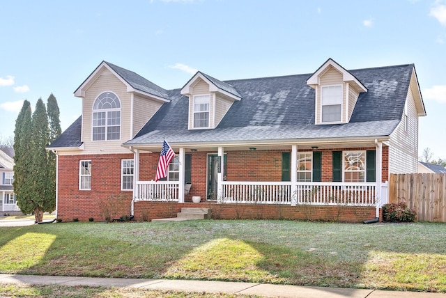 cape cod home featuring covered porch and a front lawn