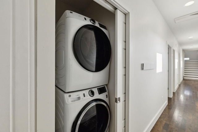 washroom with dark hardwood / wood-style flooring and stacked washer and clothes dryer