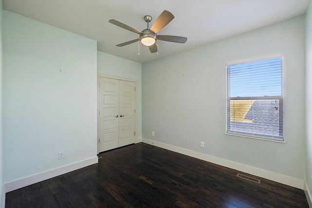 empty room with dark hardwood / wood-style floors and ceiling fan