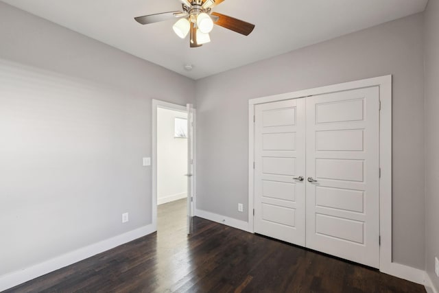 unfurnished bedroom with dark hardwood / wood-style flooring, ceiling fan, and a closet