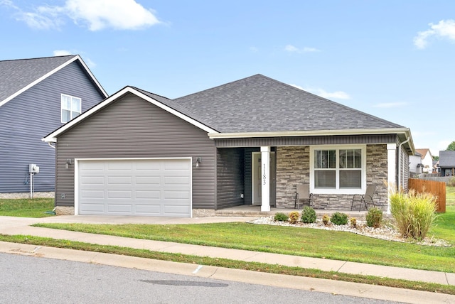 view of front facade featuring a front yard, a porch, and a garage