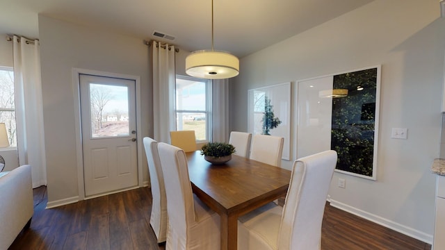 dining space with dark wood-type flooring and a wealth of natural light