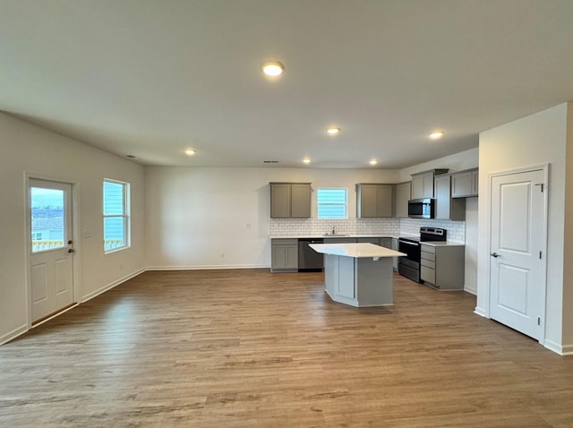 kitchen featuring sink, a center island, light hardwood / wood-style flooring, appliances with stainless steel finishes, and gray cabinets