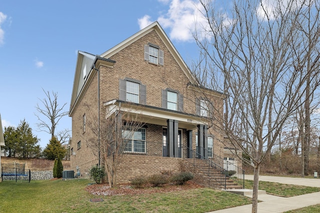 view of front of home featuring central air condition unit, a front lawn, and a porch