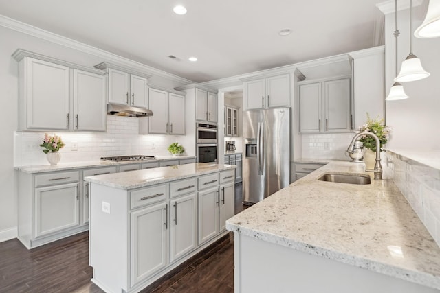 kitchen featuring decorative backsplash, light stone counters, stainless steel appliances, sink, and pendant lighting