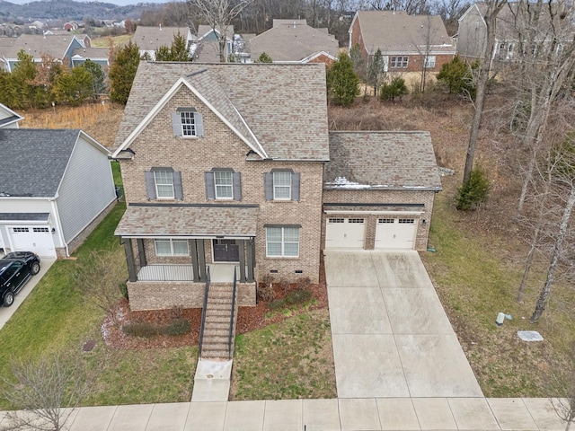 view of front of home with a front lawn, covered porch, and a garage