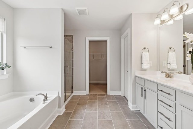 bathroom featuring tile patterned flooring, vanity, and plus walk in shower