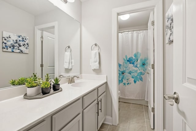 bathroom featuring tile patterned flooring, a shower with curtain, vanity, and toilet