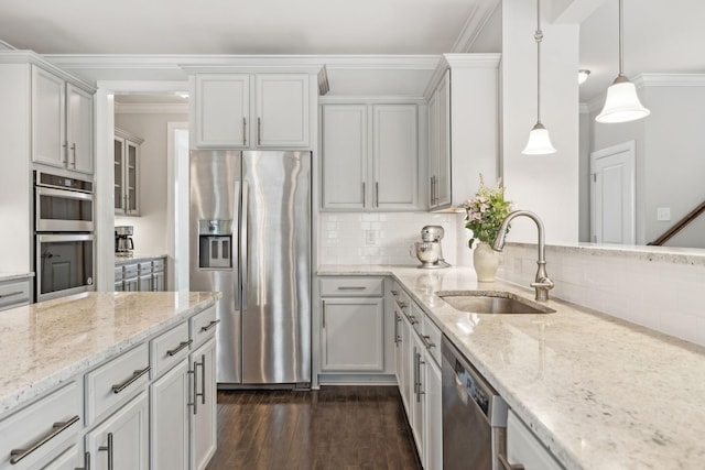 kitchen with sink, stainless steel appliances, backsplash, crown molding, and decorative light fixtures