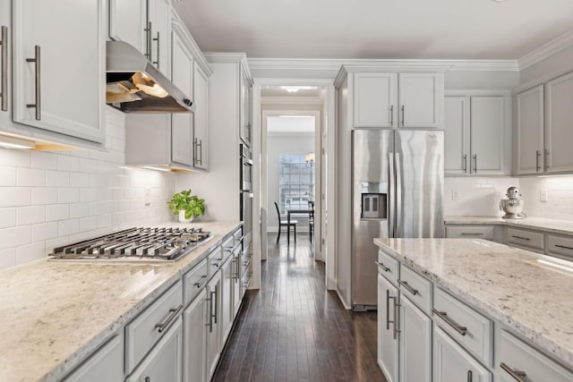 kitchen with decorative backsplash, stainless steel appliances, light stone counters, and ornamental molding