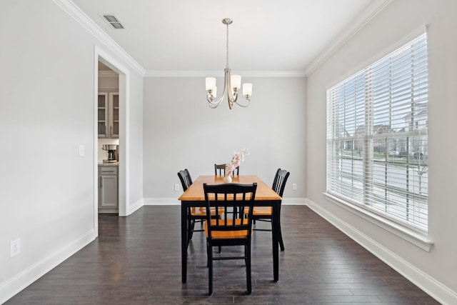 dining area featuring ornamental molding, dark wood-type flooring, and a chandelier