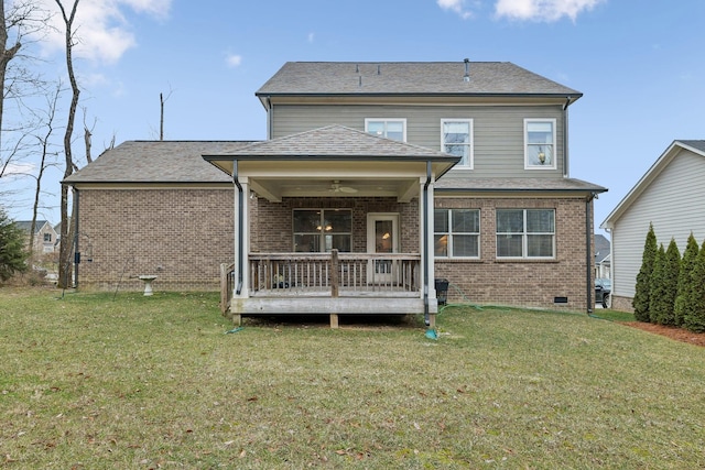 rear view of property featuring ceiling fan and a yard