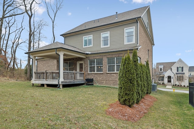 rear view of house featuring a yard and central AC unit