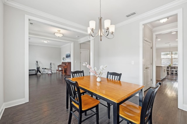 dining area with dark hardwood / wood-style flooring, crown molding, and a chandelier