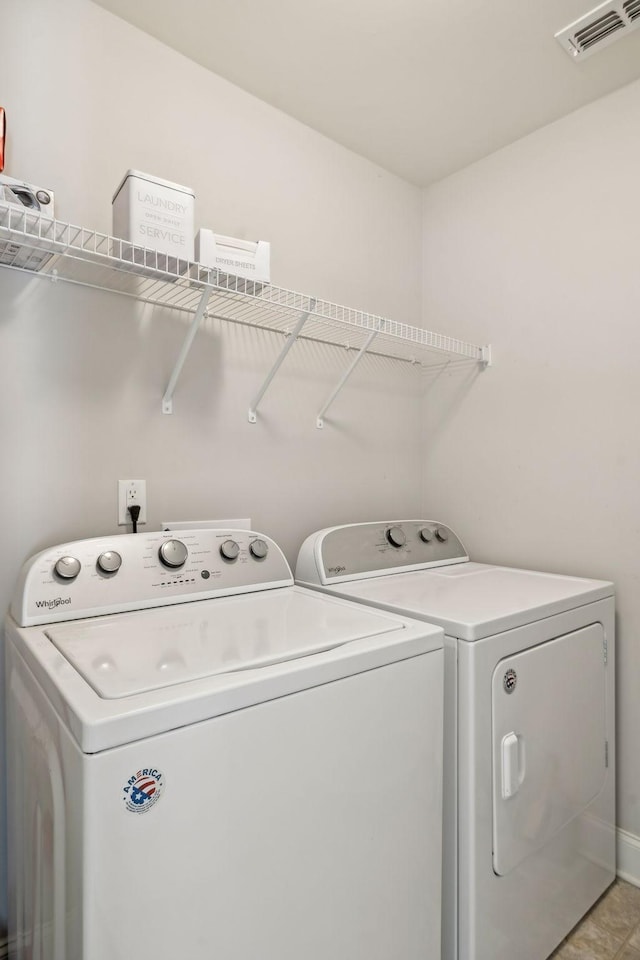 laundry area featuring independent washer and dryer and light tile patterned floors