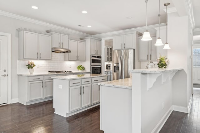 kitchen featuring hanging light fixtures, light stone countertops, appliances with stainless steel finishes, tasteful backsplash, and kitchen peninsula