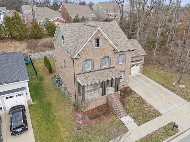 front facade with a garage, a porch, and a front yard