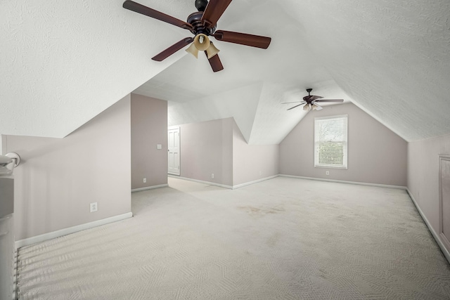 bonus room with light carpet, a textured ceiling, and ceiling fan