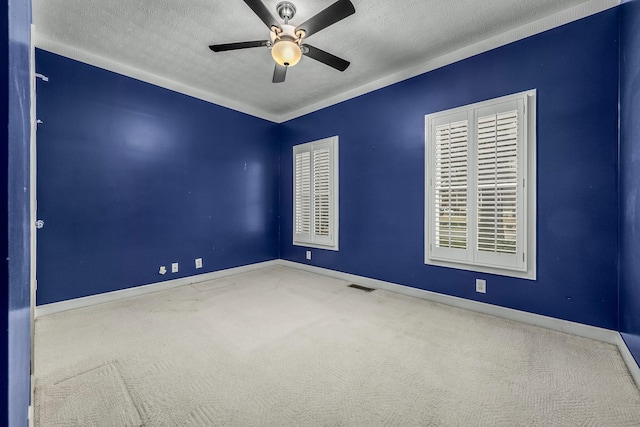 carpeted spare room featuring ceiling fan and a textured ceiling