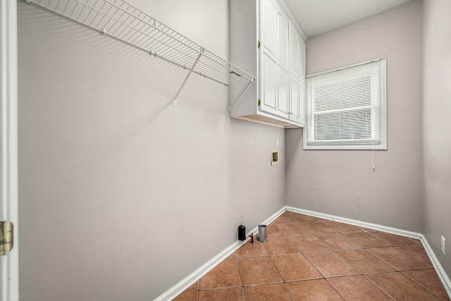 laundry area with cabinets, light tile patterned floors, and hookup for a washing machine