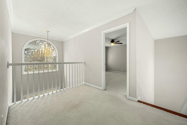 hall featuring light colored carpet, crown molding, and a notable chandelier