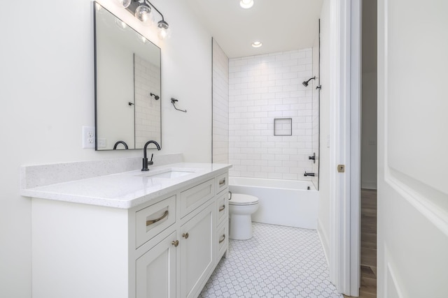 full bathroom with tiled shower / bath, tile patterned flooring, vanity, and toilet