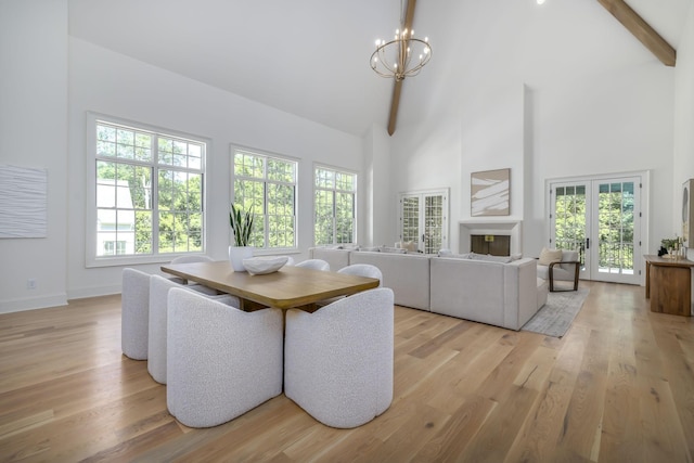 dining area with beam ceiling, a chandelier, high vaulted ceiling, and light hardwood / wood-style floors