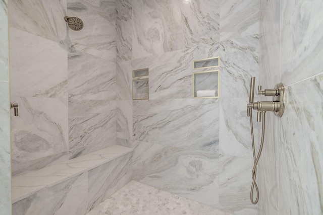 interior details featuring tiled shower