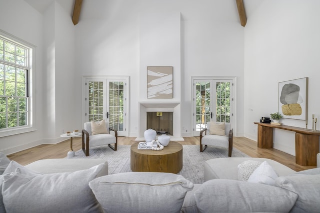 living room with french doors, a wealth of natural light, and beam ceiling