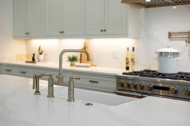 kitchen featuring high end stove and light stone countertops