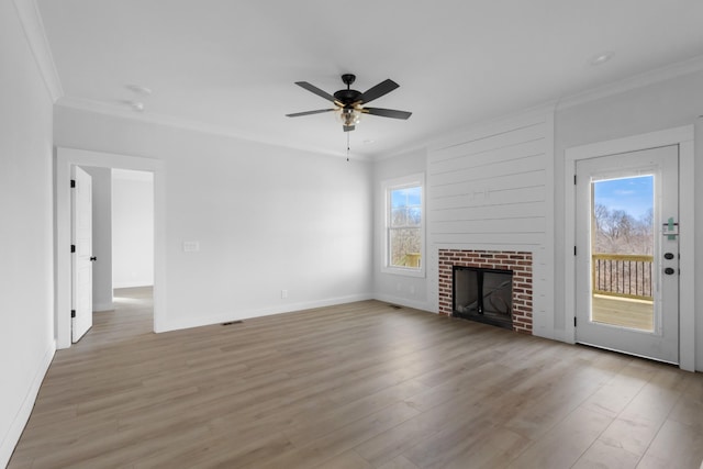 unfurnished living room with a fireplace, crown molding, light wood-style floors, and ceiling fan