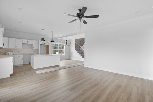 unfurnished living room with stairs, light wood-type flooring, a ceiling fan, and crown molding