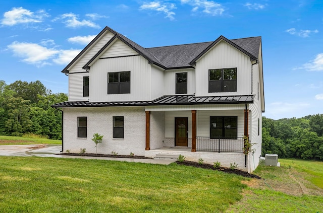 983 Palmyra Rd, Clarksville, TN 37040 - modern inspired farmhouse with covered porch, brick siding, a standing seam roof, and a front yard