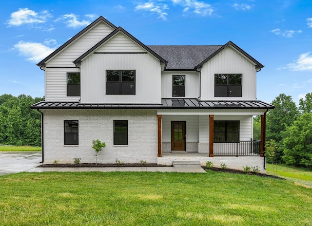 983 Palmyra Rd, Clarksville, TN 37040 - modern inspired farmhouse featuring brick siding, covered porch, a standing seam roof, and a front lawn
